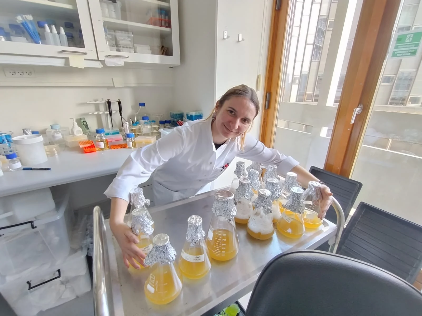 A group member with a trolley of flasks in the laboratory